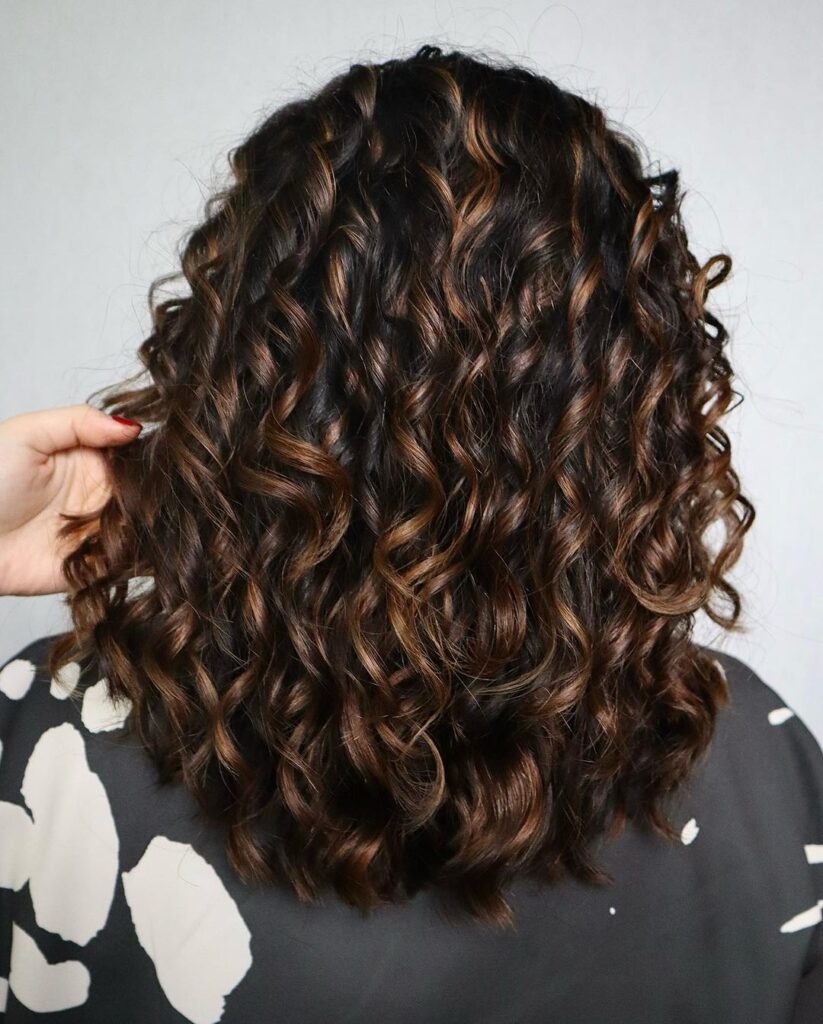 layered sweet golden caramel highlights on curly hair