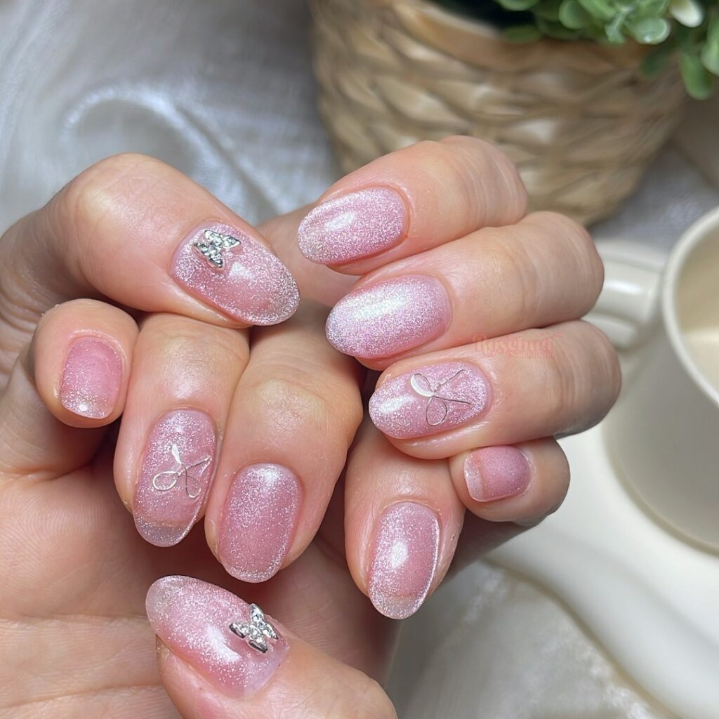 unhas brilhantes cor-de-rosa com pedras preciosas