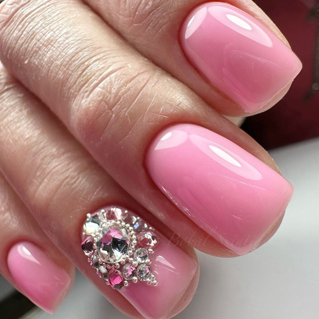 ongles roses avec une grosse pierre précieuse