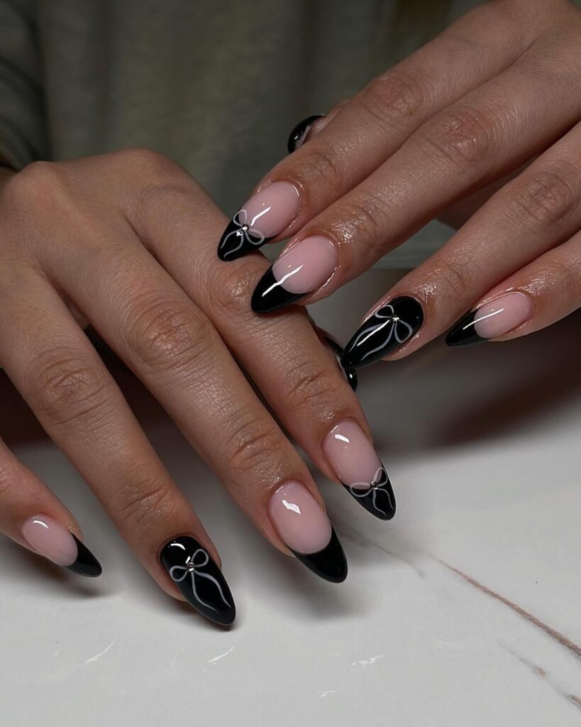 Unhas pretas com um laço