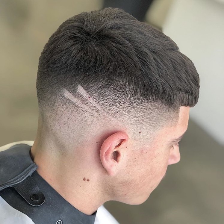 cesar cut with a high skin fade and shaved lines