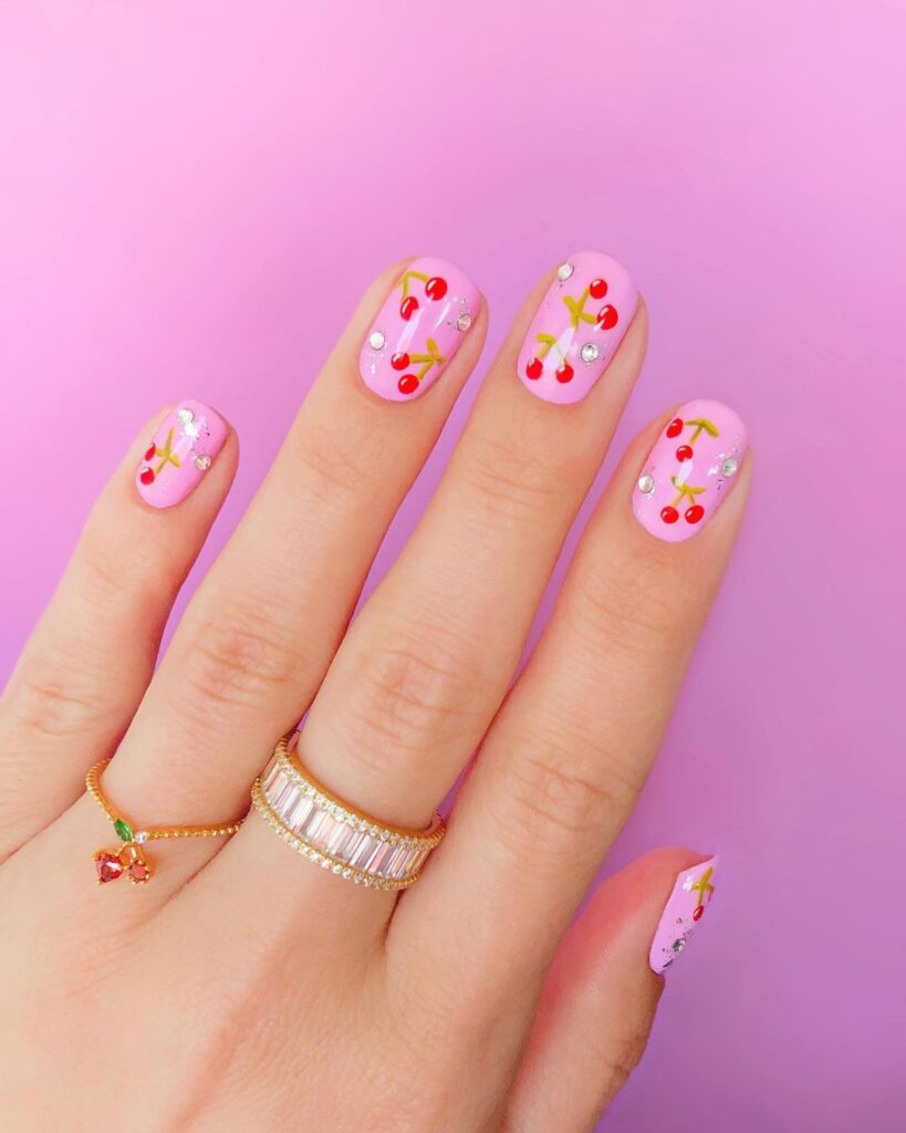 Unhas curtas cor-de-rosa com cerejas