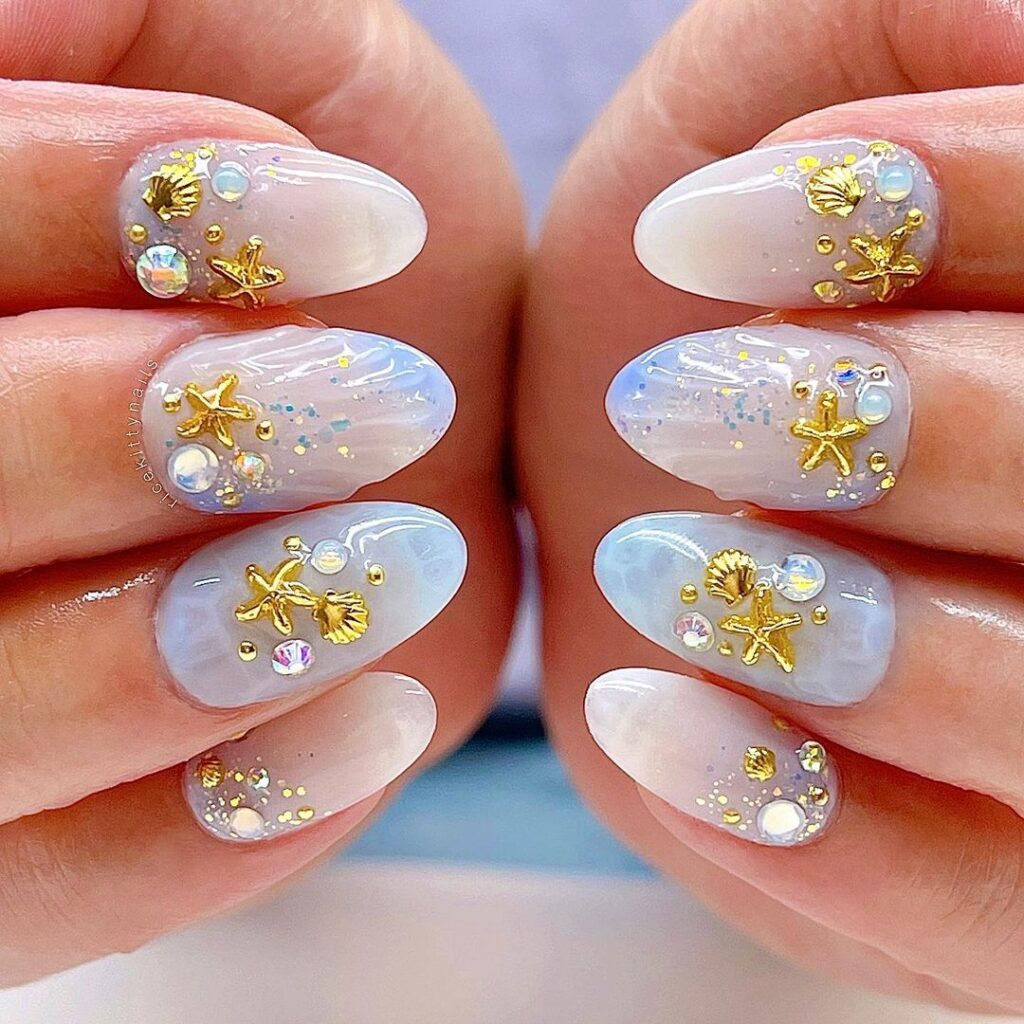 elegantes uñas de sirena blancas y doradas