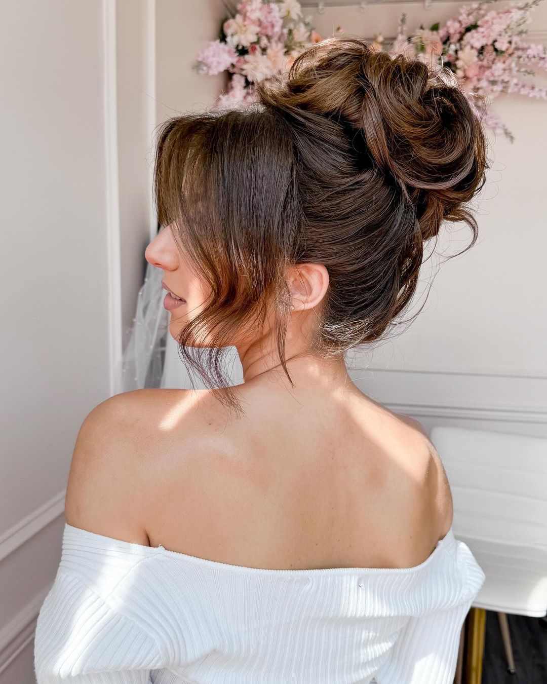 textured high bun with curtain bangs