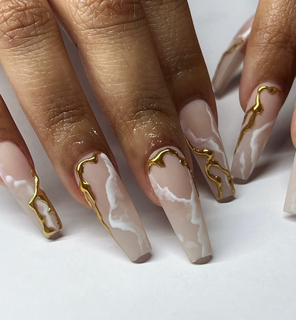 unhas de mármore com revestimento dourado