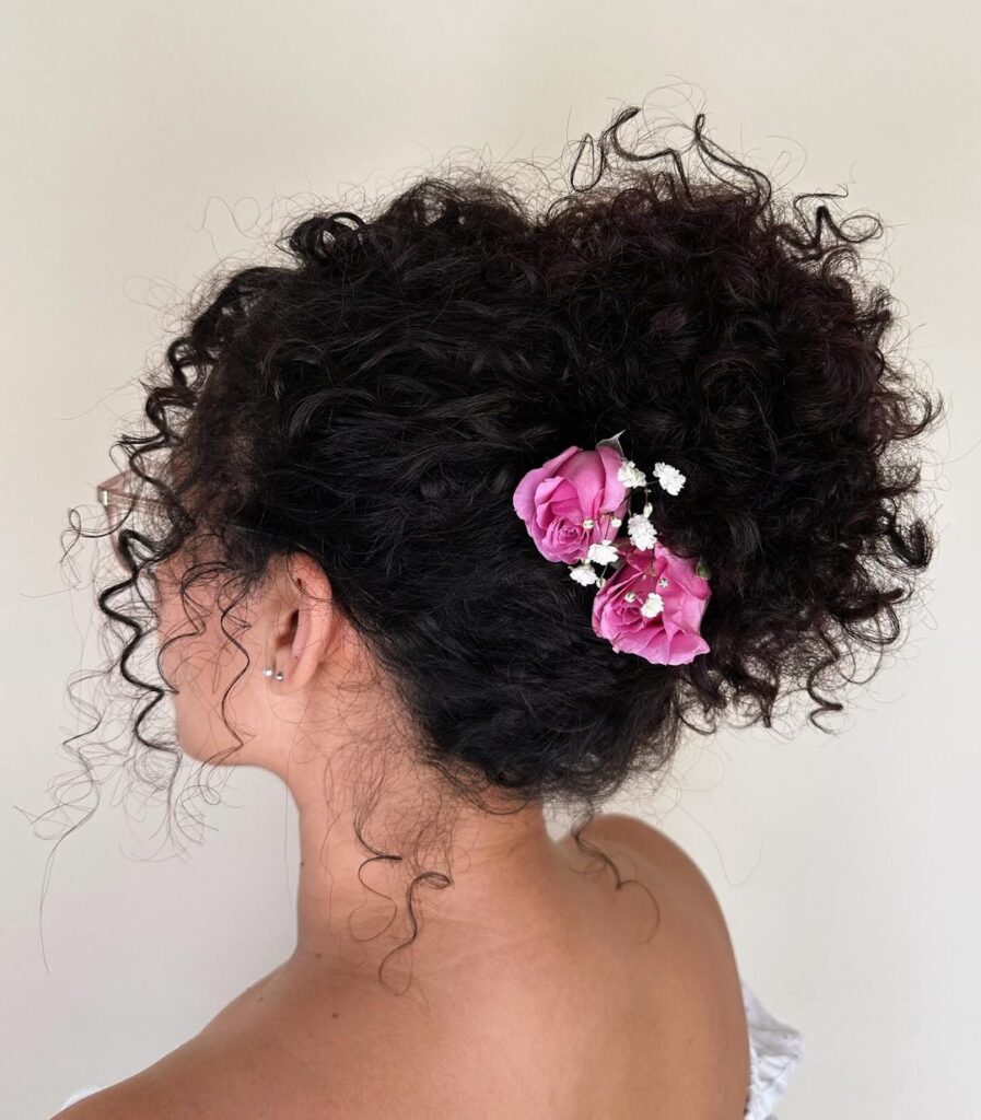 updo alto con fiori per ricci naturali