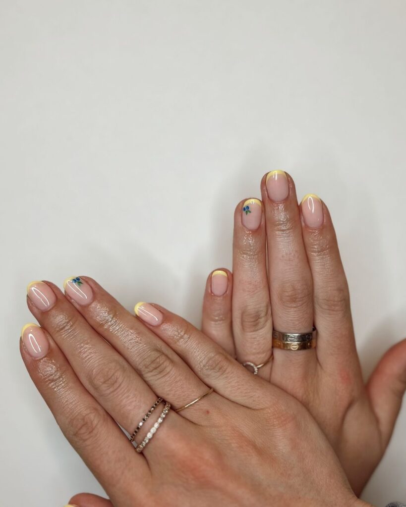 subtle blueberry art on yellow french mani