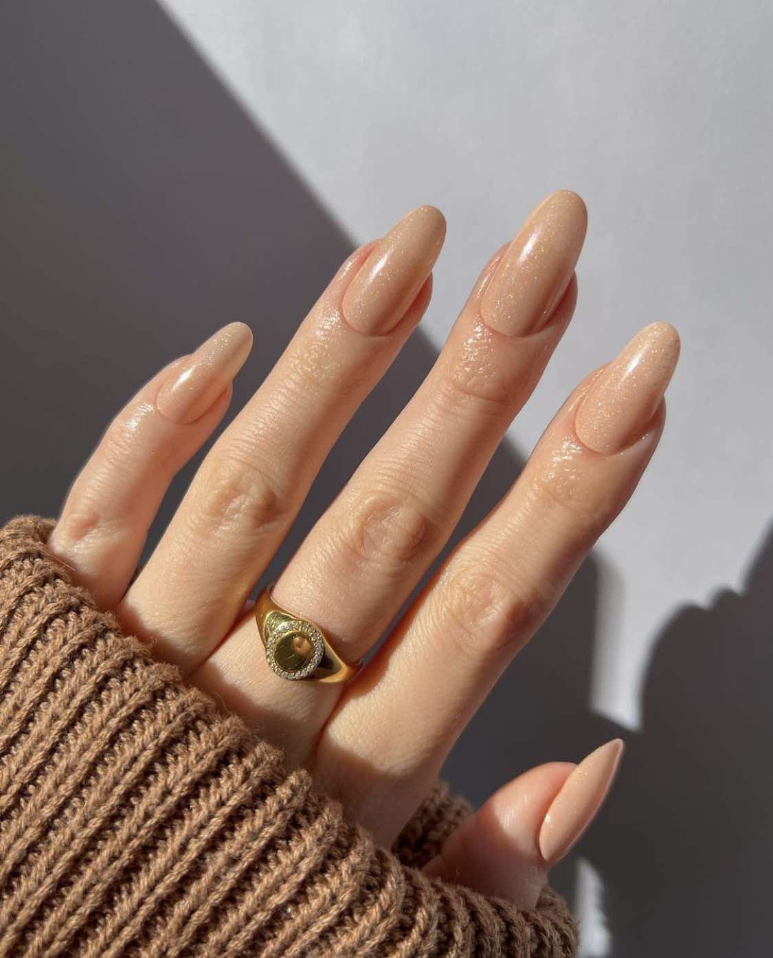 Ongles d'automne dorés et brillants en forme d'amande