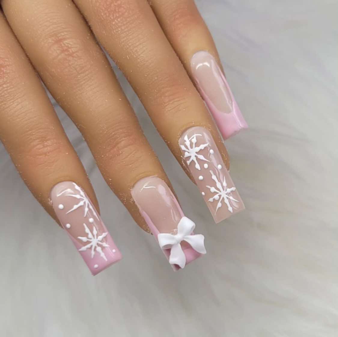 Design de unhas com laço cor-de-rosa de inverno