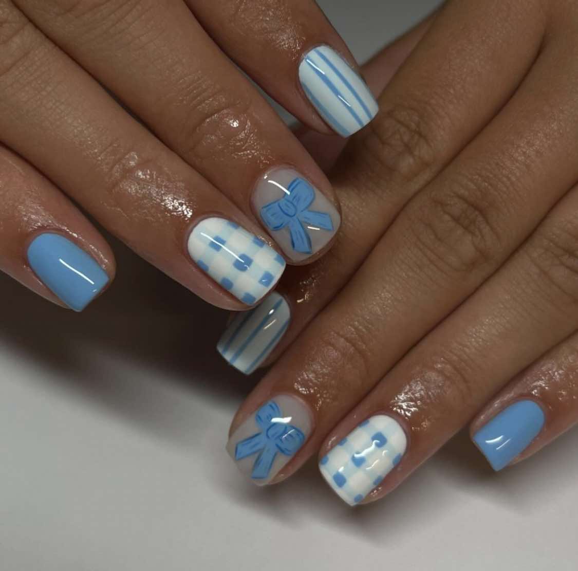 Modèle d'ongles courts avec nœud bleu