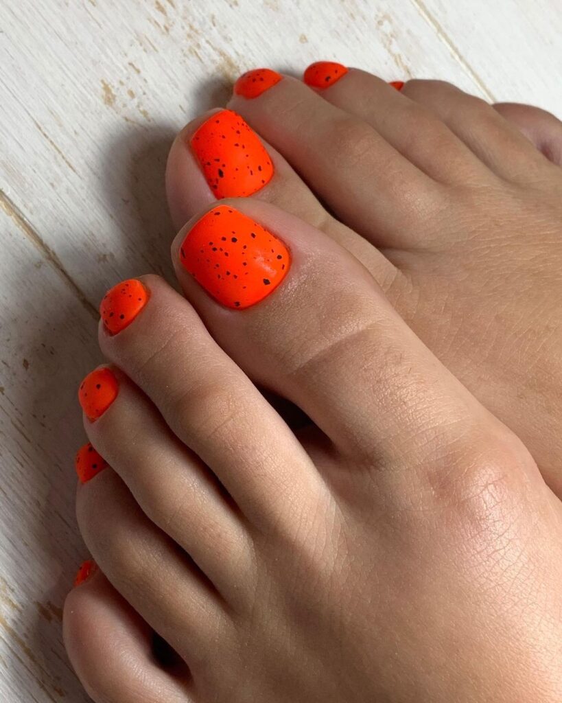 Uñas de los pies rojo anaranjado