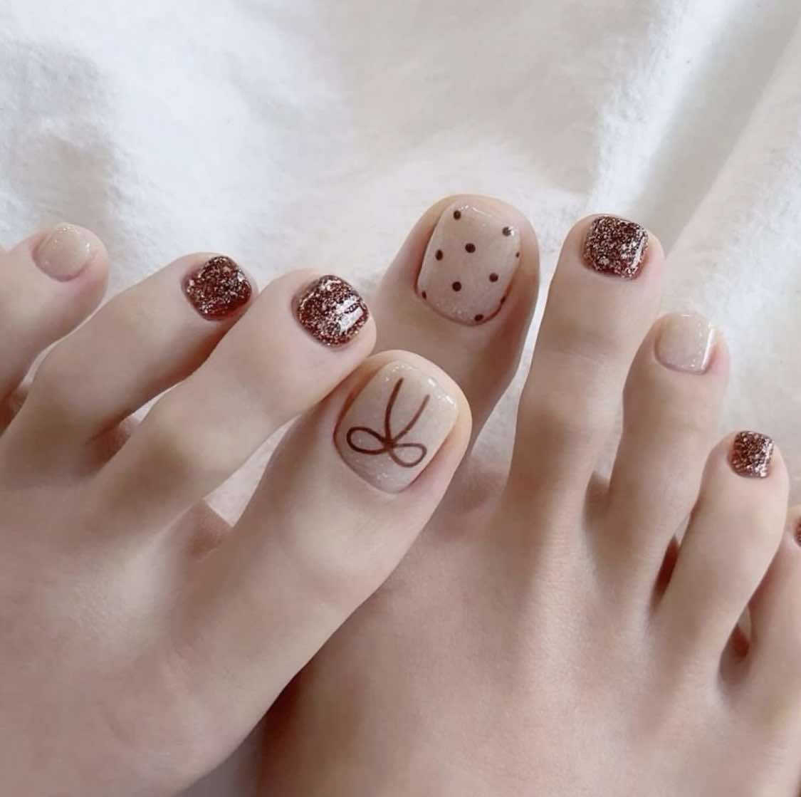 Unhas dos pés em tons de nude e castanho