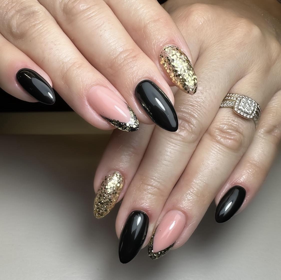 Unghie a mandorla con glitter nero e oro