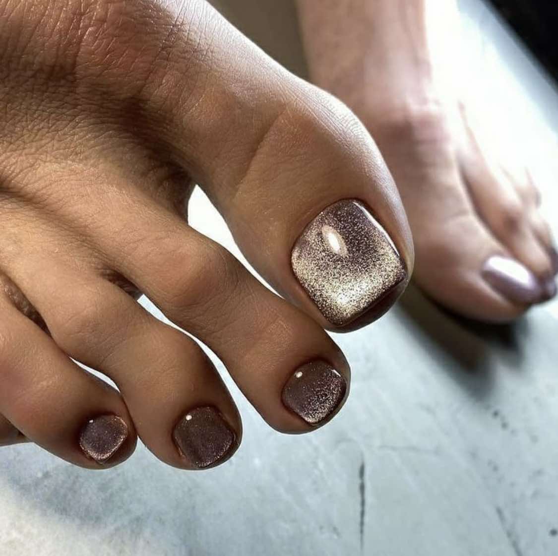 Uñas de los pies marrones con acabado plateado