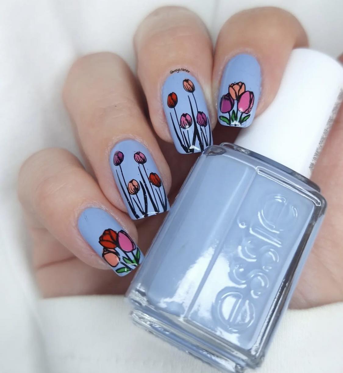 Uñas azul claro con tulipanes