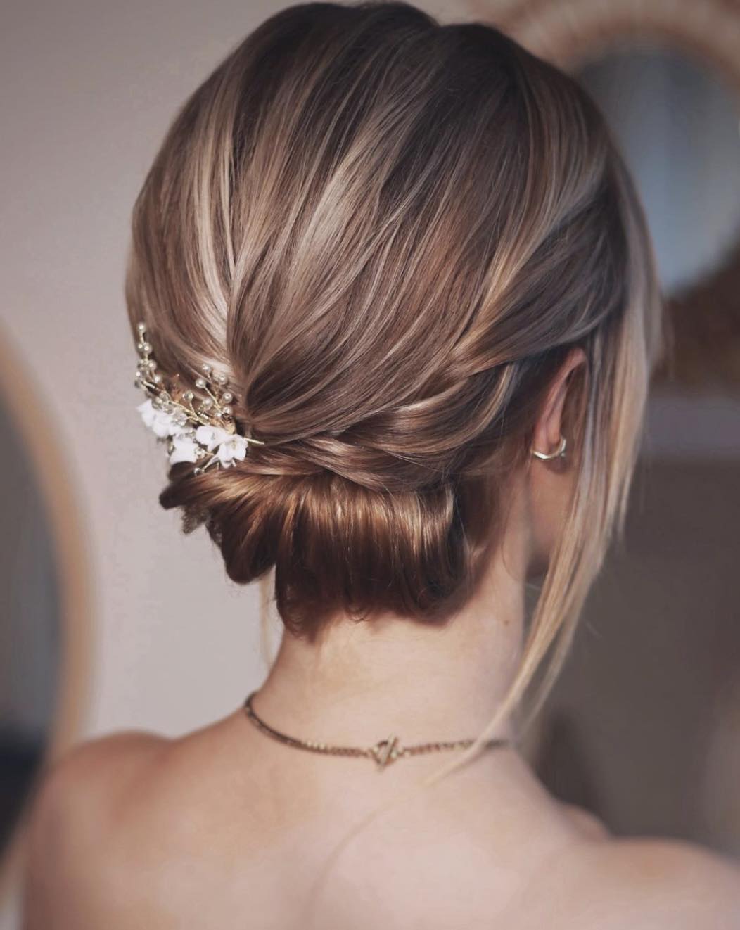 Penteado Hoco com coque baixo e flores