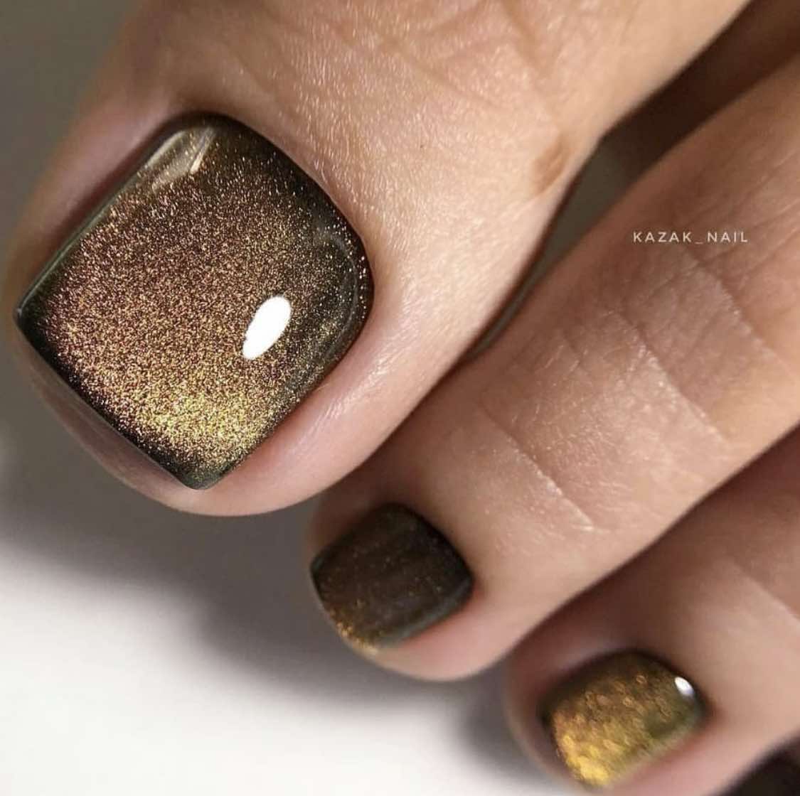 Uñas de los pies marrones con acabado dorado