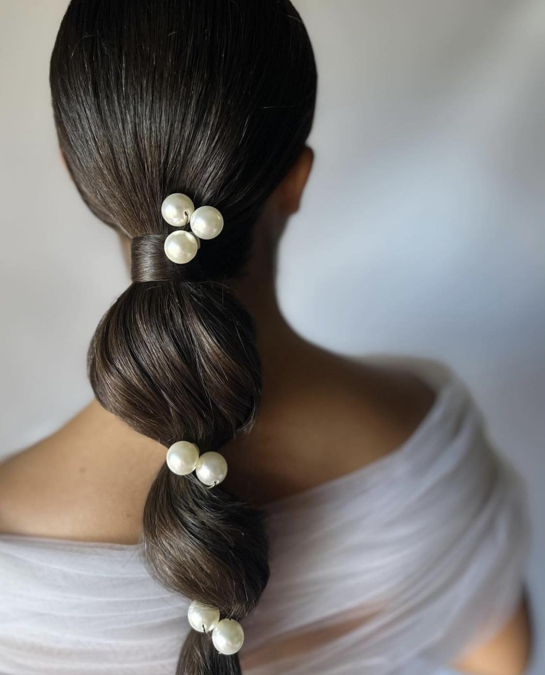 Penteado com rabo-de-cavalo torcido e elegante com pérolas