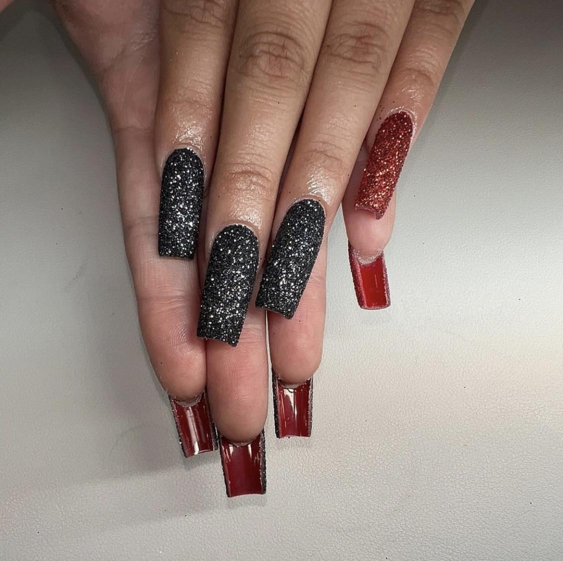 Ongles rouges et noirs à paillettes