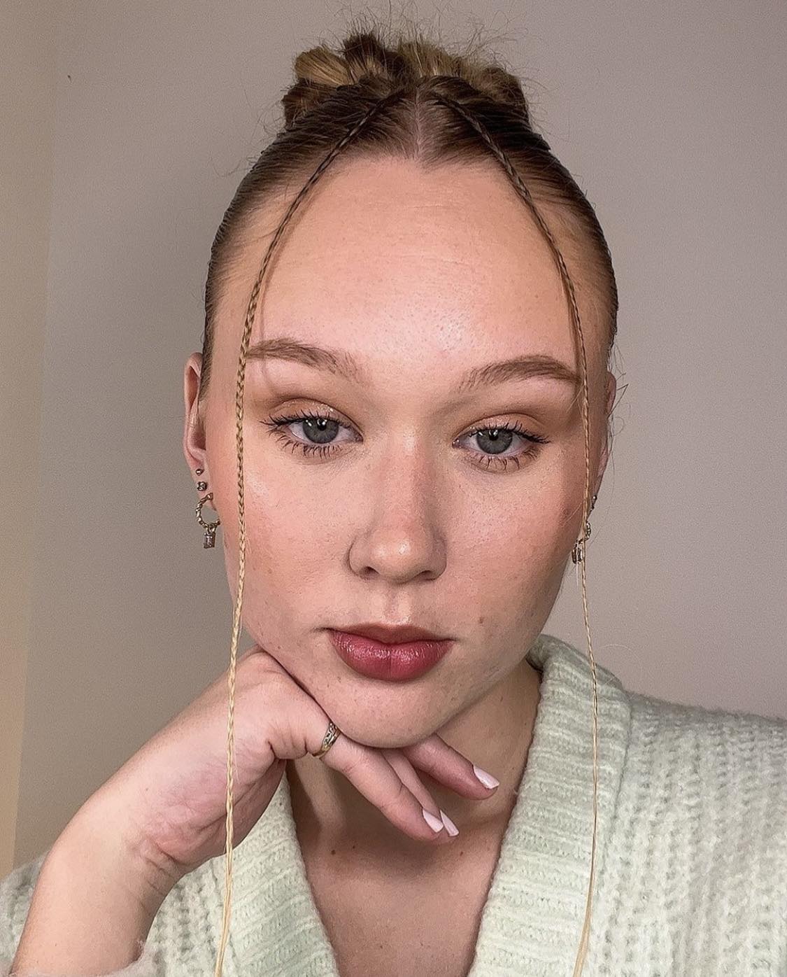 Coiffure de bébé avec tresses et cheveux lissés vers l'arrière