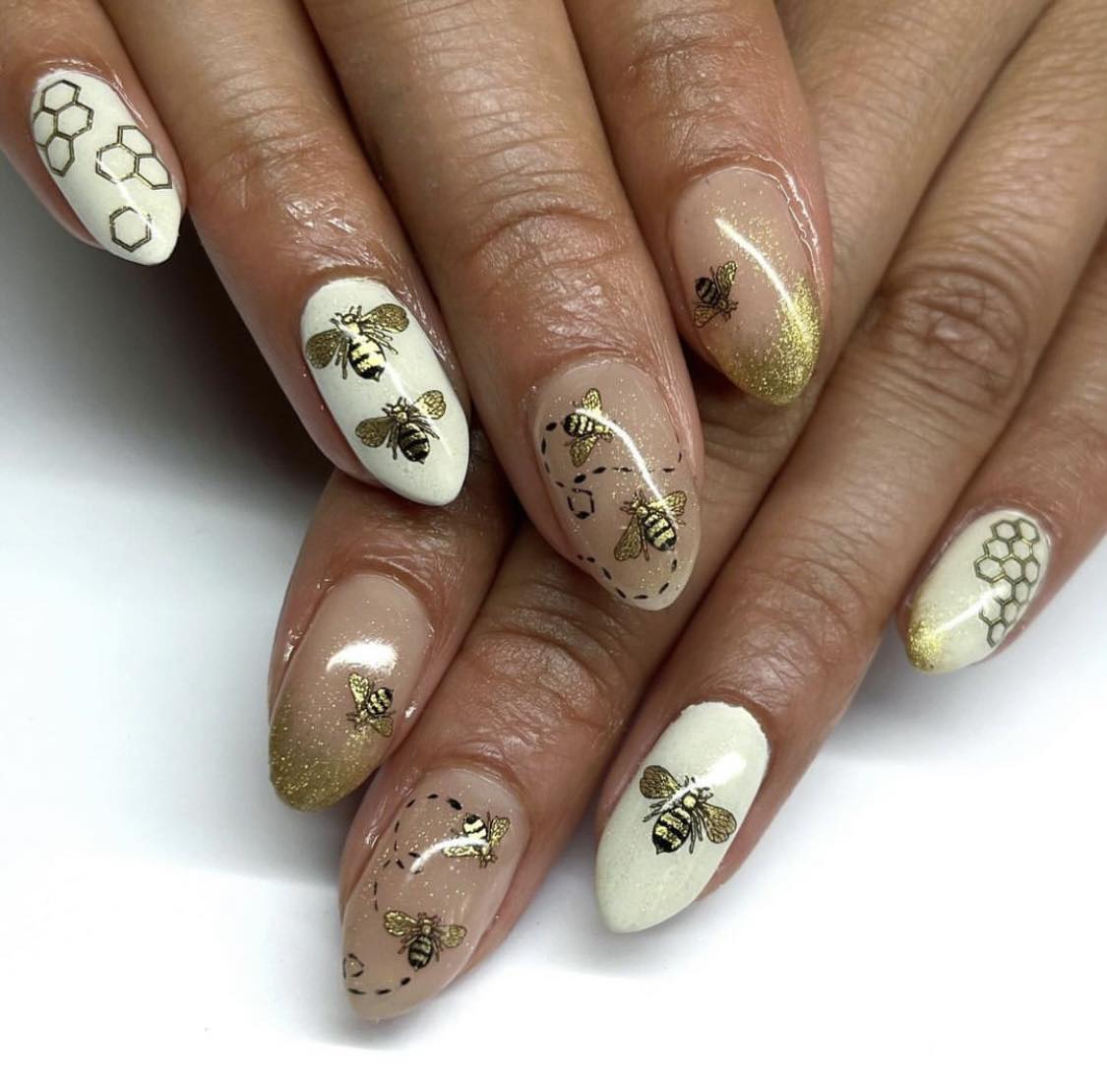 Unhas brancas e douradas com abelhas