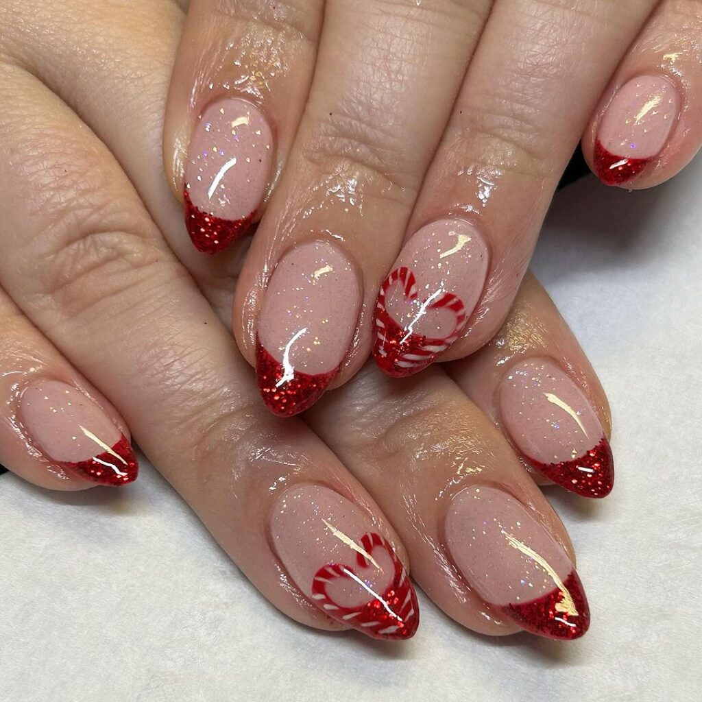 Uñas con purpurina y corazón de bastón de caramelo