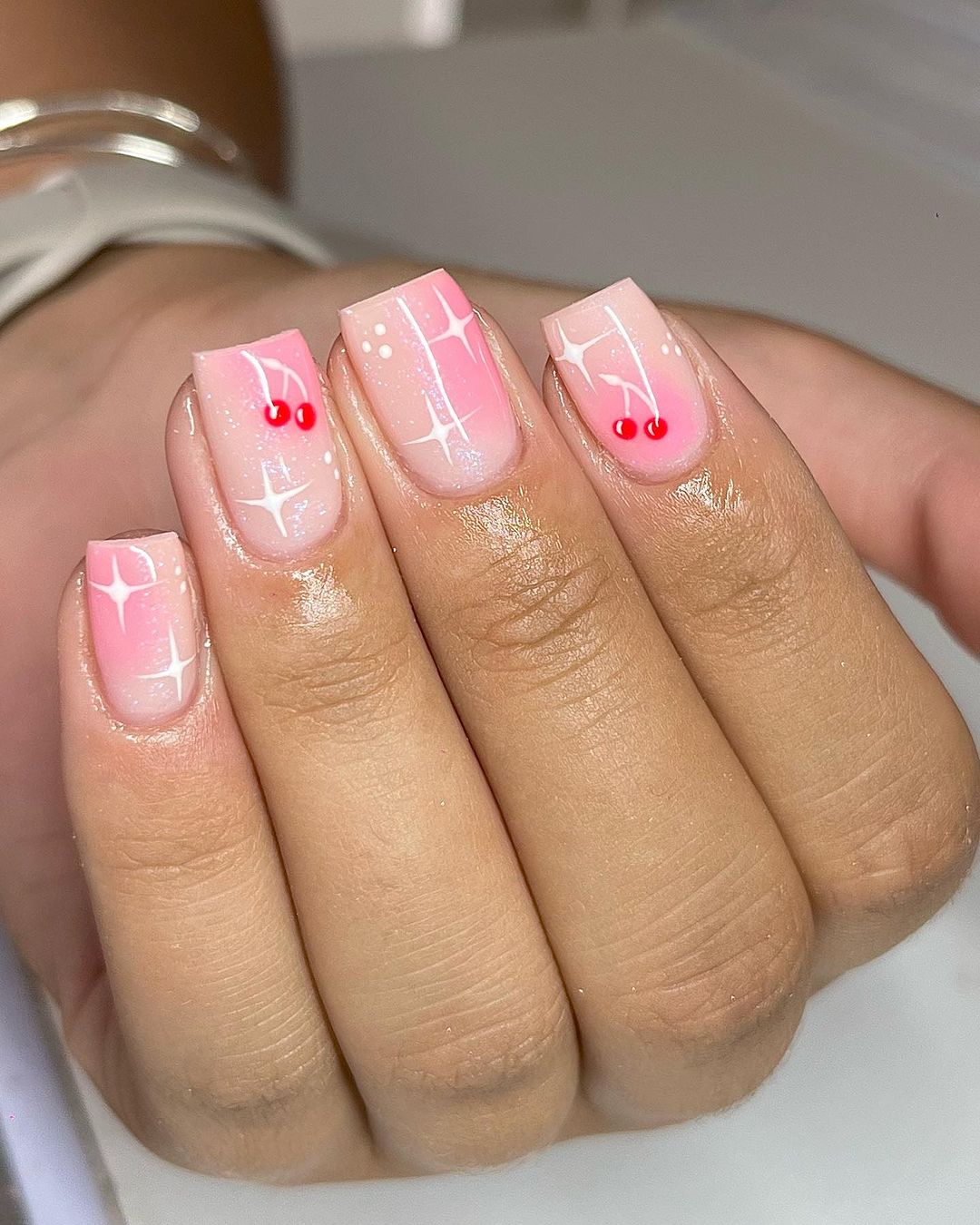 unhas brilhantes com cereja no topo