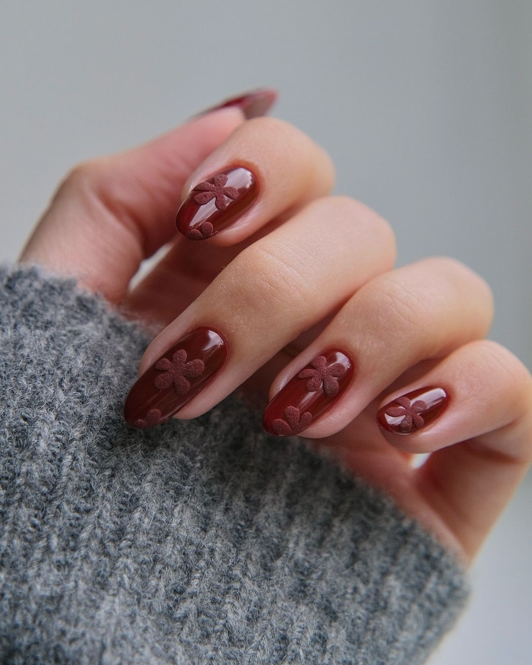 unhas cor de vinho com toque florido